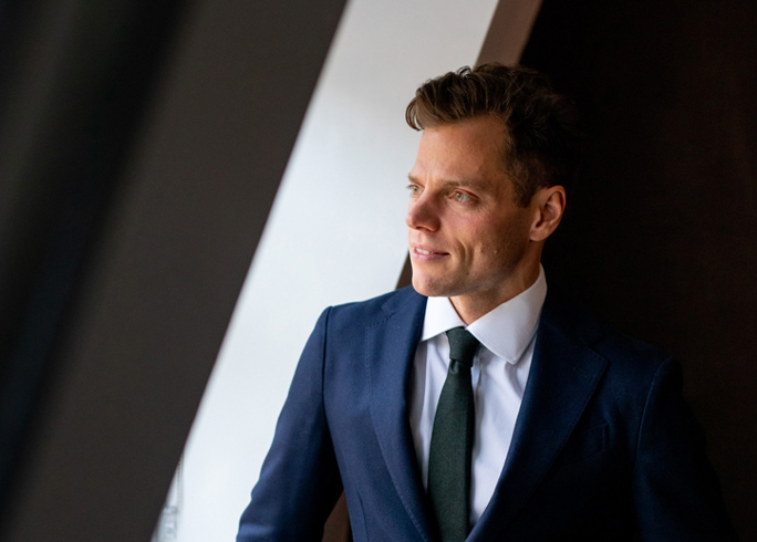 Headshot of Max Bassadone looking out a window 