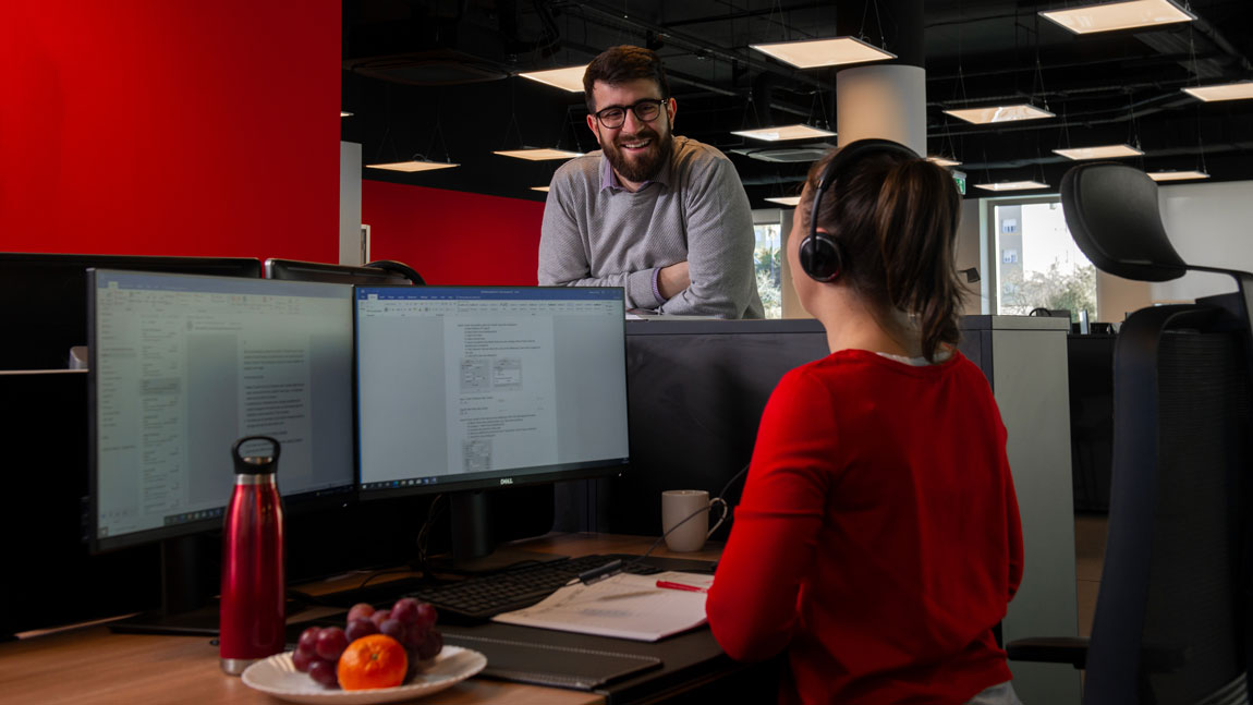Two people having conversation at desk