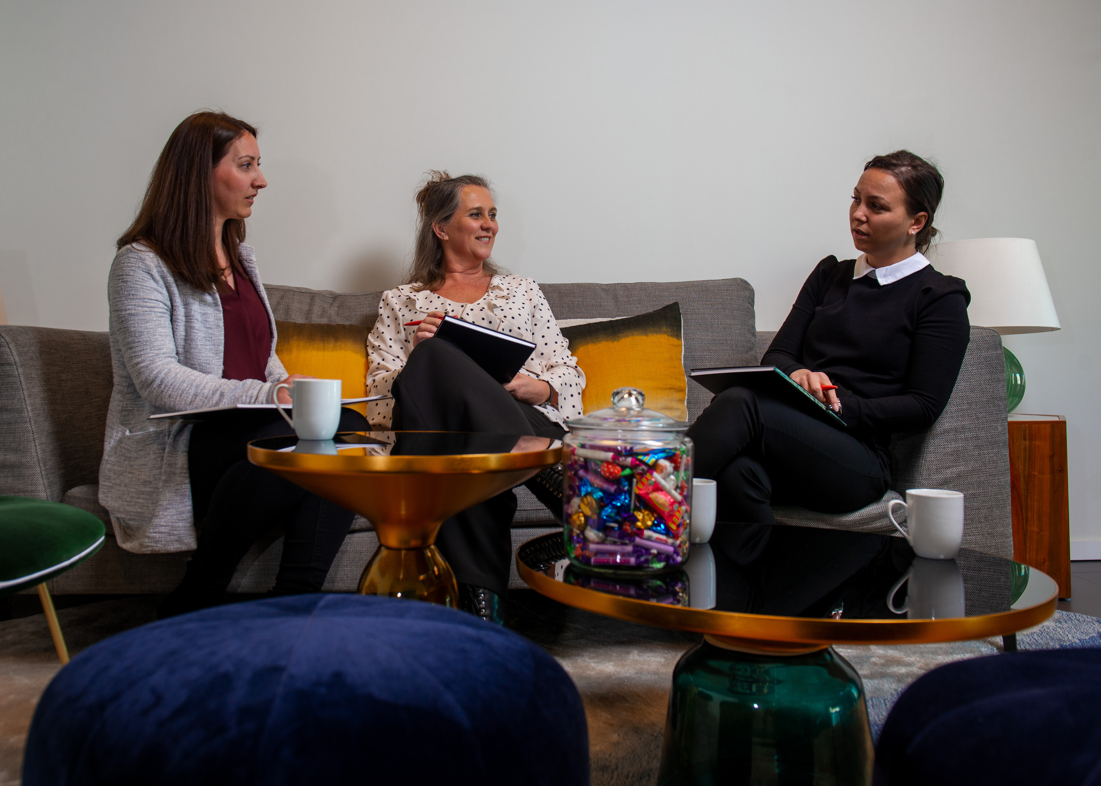 Three people sat on sofa having a meeting