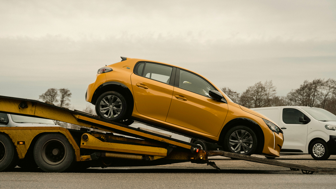 Car going down a ramp of transporter truck