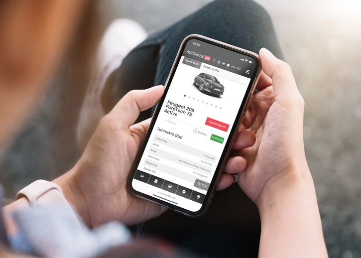 Person holding a phone displaying the Autohalle website