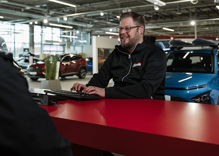 A person typing at a computer in the AMG showrrom